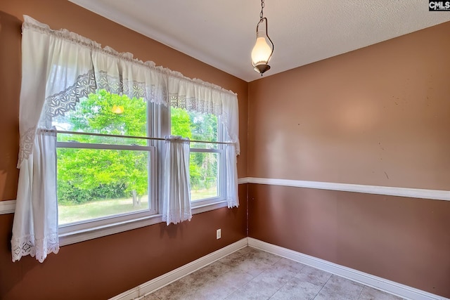 unfurnished room featuring baseboards and light tile patterned flooring
