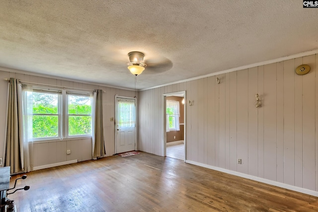 unfurnished room with crown molding, a textured ceiling, ceiling fan, and wood finished floors