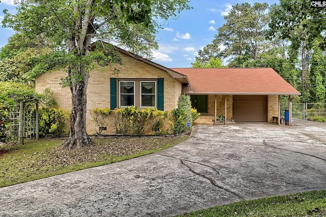 single story home with concrete driveway, brick siding, an attached garage, and fence