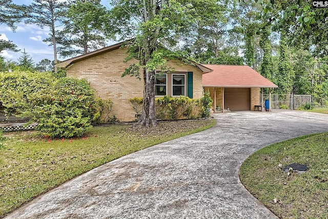 view of front facade featuring fence, an attached garage, driveway, and brick siding