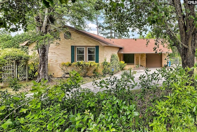 view of front of house featuring fence, an attached garage, concrete driveway, and brick siding