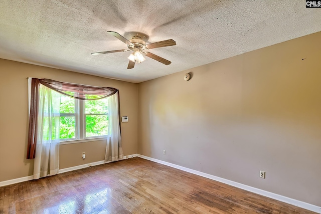 spare room featuring baseboards, a ceiling fan, a textured ceiling, and wood finished floors