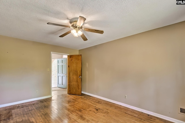 spare room with baseboards, a textured ceiling, ceiling fan, and hardwood / wood-style floors