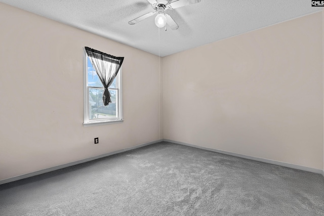 carpeted spare room featuring baseboards, ceiling fan, and a textured ceiling
