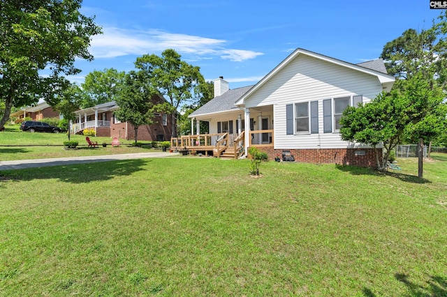 rear view of property featuring covered porch, crawl space, a yard, and a chimney
