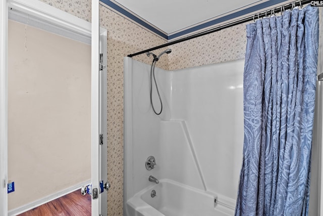 bathroom with shower / bath combo with shower curtain, wood finished floors, and wallpapered walls
