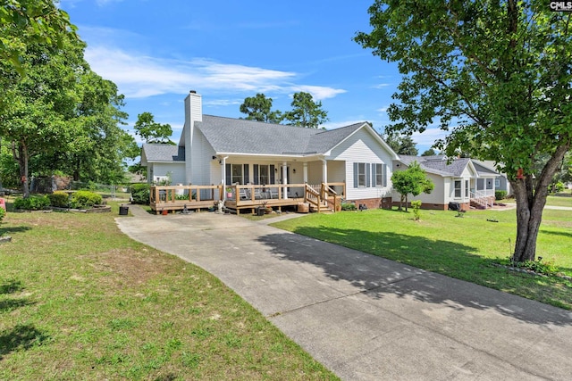 view of front facade with a front yard, a chimney, a shingled roof, crawl space, and driveway