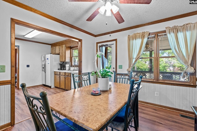 dining space featuring visible vents, wood finished floors, baseboards, ceiling fan, and a textured ceiling