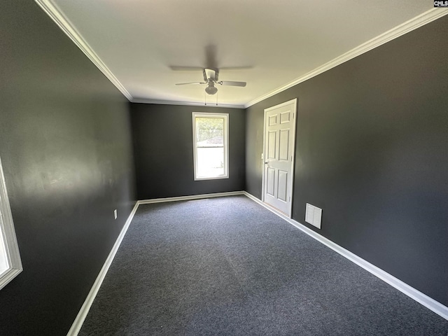 carpeted empty room with crown molding, baseboards, a ceiling fan, and visible vents