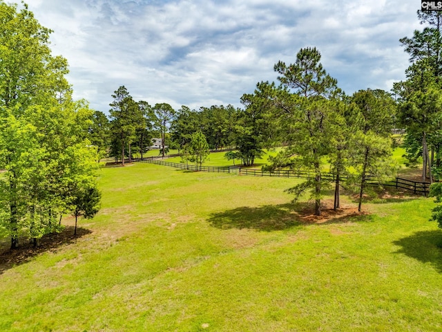 view of yard featuring fence and a rural view