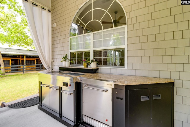 view of patio / terrace with fence, a sink, and exterior kitchen