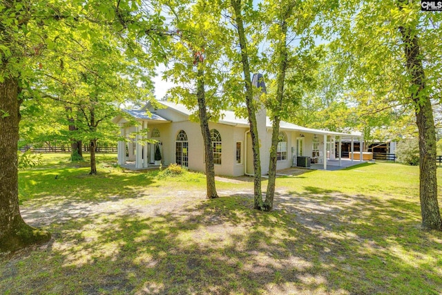 rear view of property featuring a lawn and a patio area