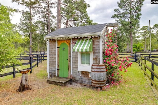 view of outbuilding with fence and an outbuilding
