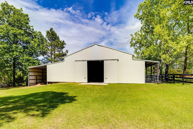 view of pole building featuring a lawn and fence