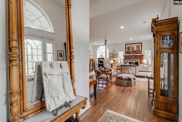 foyer entrance featuring a fireplace, recessed lighting, and wood finished floors