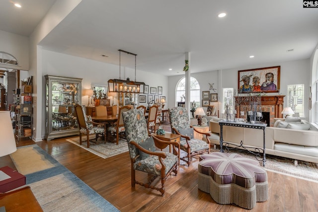 living room featuring a brick fireplace, recessed lighting, and wood finished floors