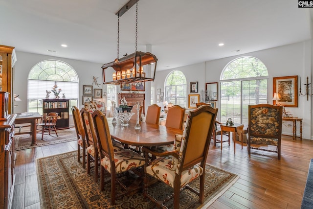 dining space featuring a fireplace, hardwood / wood-style flooring, visible vents, and recessed lighting