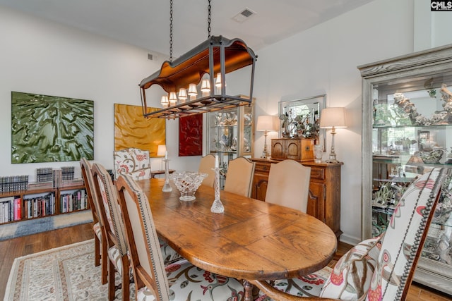 dining room featuring a chandelier, visible vents, and wood finished floors