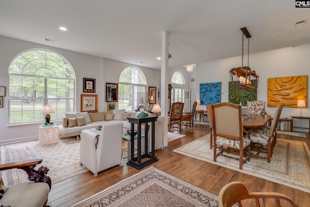 living area with recessed lighting, visible vents, and wood finished floors