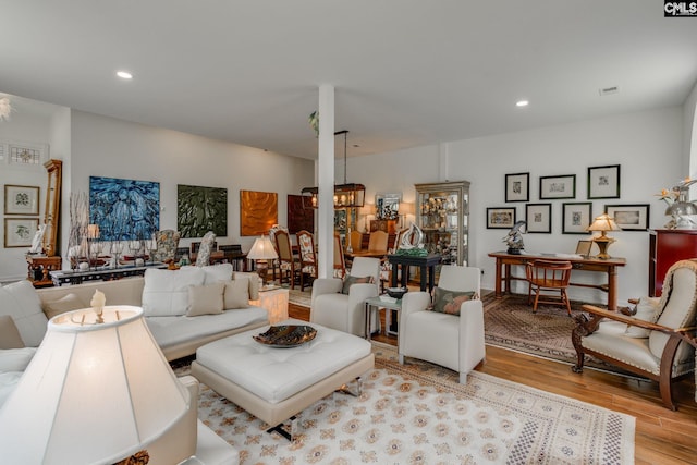 living area featuring recessed lighting, a notable chandelier, and wood finished floors