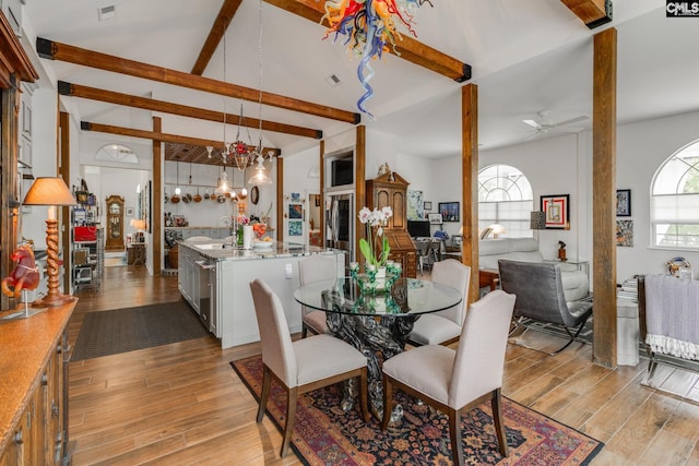 dining area with vaulted ceiling with beams, ceiling fan with notable chandelier, visible vents, and light wood-style floors