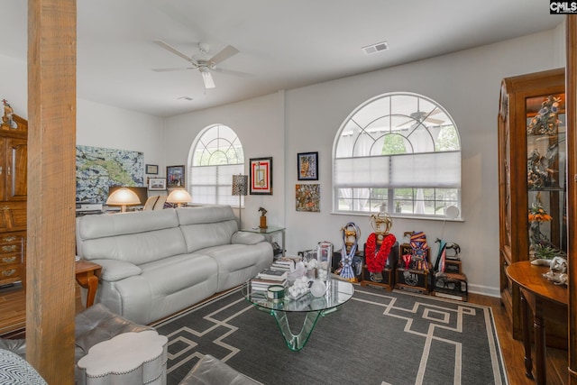 living area featuring ceiling fan, visible vents, and wood finished floors