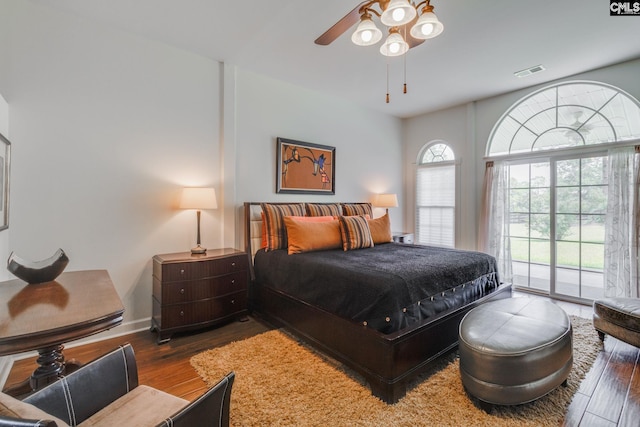 bedroom featuring wood finished floors, visible vents, a ceiling fan, baseboards, and access to exterior