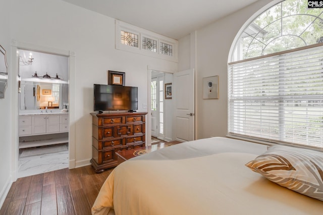 bedroom featuring ensuite bathroom, marble finish floor, and multiple windows