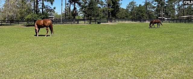 view of community featuring a lawn, an enclosed area, and fence