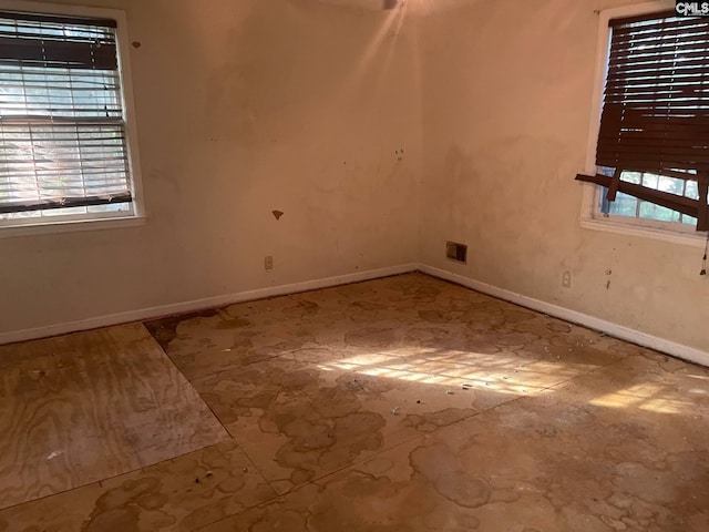 empty room featuring baseboards and visible vents