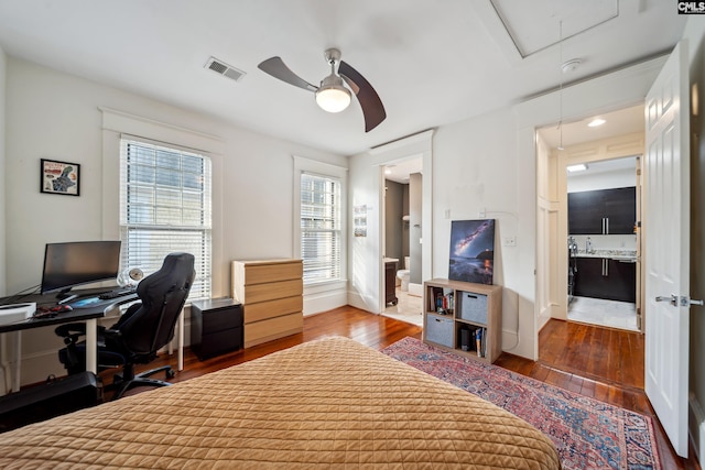 bedroom featuring ensuite bath, visible vents, attic access, and hardwood / wood-style floors