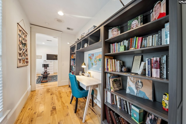 interior space with baseboards, visible vents, and wood finished floors