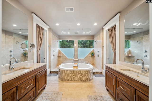 full bath with a sink, a tile shower, and visible vents