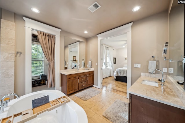 ensuite bathroom featuring visible vents, a sink, connected bathroom, and two vanities