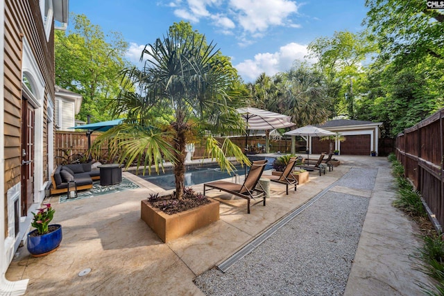 view of patio / terrace featuring a fenced backyard, a fenced in pool, an outdoor hangout area, and an outbuilding
