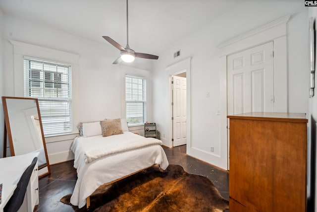 bedroom with visible vents, a ceiling fan, baseboards, and finished concrete flooring