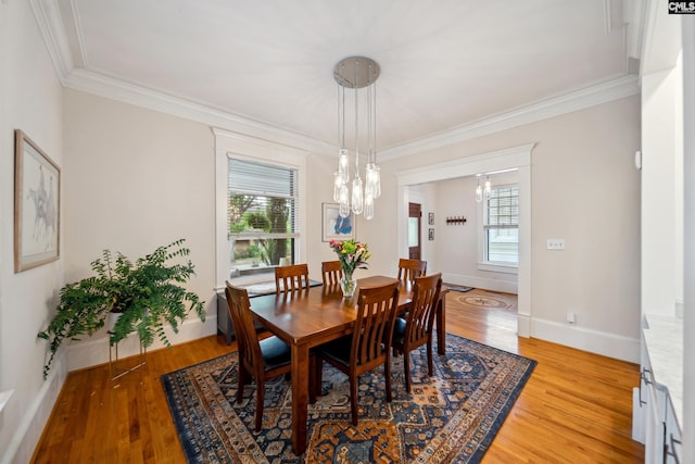 dining area with crown molding and light wood finished floors