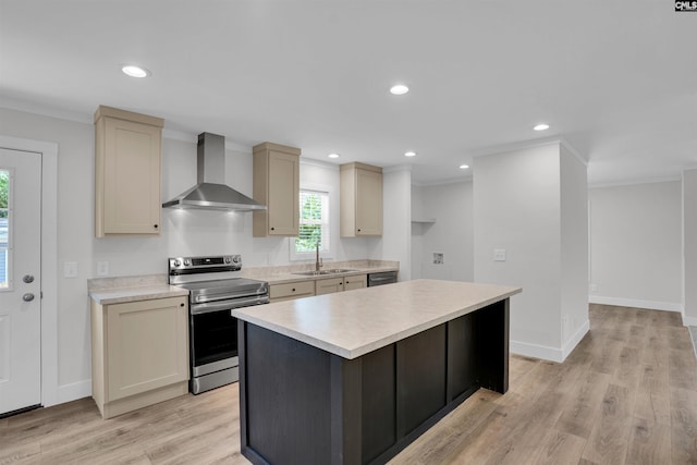 kitchen featuring a sink, stainless steel appliances, light countertops, and wall chimney range hood