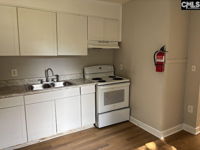 2813 Truman St, Columbia, SC 29204 - kitchen with under cabinet range hood, white electric range, a sink, wood finished floors, and white cabinets