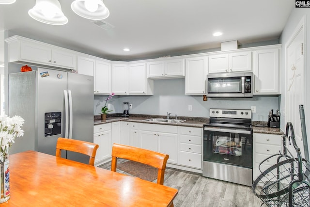 kitchen featuring light wood-style flooring, visible vents, a sink, white cabinetry, and stainless steel appliances