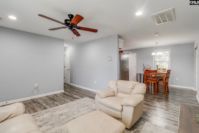 living area featuring baseboards, visible vents, and wood finished floors