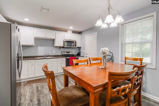 dining area with visible vents, baseboards, light wood-style floors, a chandelier, and recessed lighting