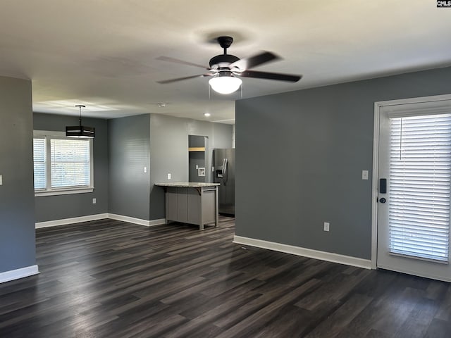 629 Crystal Creek Cir, Chapin, SC 29036 - unfurnished living room featuring dark wood-type flooring, baseboards, and a ceiling fan
