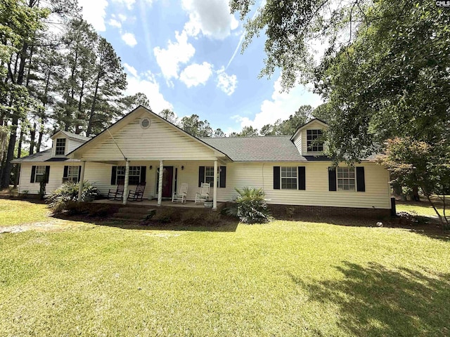 view of front facade featuring covered porch, a shingled roof, and a front lawn