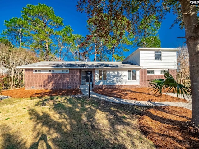 view of front facade featuring a front lawn, brick siding, and crawl space