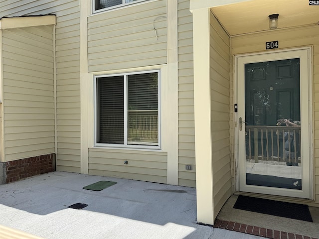 view of exterior entry with a patio