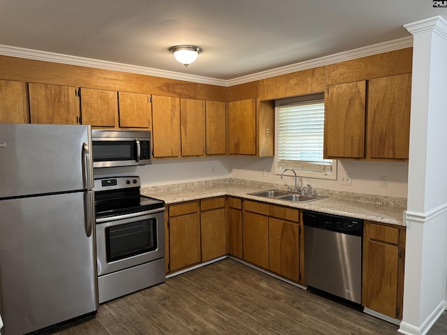kitchen featuring light countertops, stainless steel appliances, brown cabinetry, and a sink