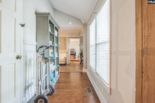 hallway featuring lofted ceiling, visible vents, and dark wood-style floors