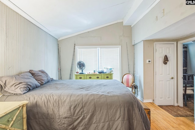 bedroom featuring vaulted ceiling, ornamental molding, and hardwood / wood-style floors
