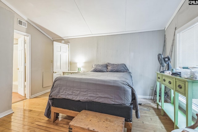 bedroom featuring light wood-type flooring, baseboards, connected bathroom, and visible vents